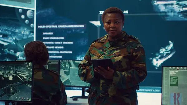 stock image Woman sergeant major working on deployment of electronic warfare tools to disrupt enemy communications. Female army soldier with camouflage uniform operating on high tech gear. Camera A.