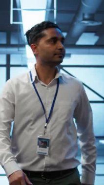 Sunucu satırları arasında yürüyen dikey video Yöneticisi, donanım uygulaması ve yönetimi ile optimal performans ve güvenilirliği sağlamaya çalışıyor. Veri merkezinde yüksek teknoloji tesisini denetleyen bilişim personeli.