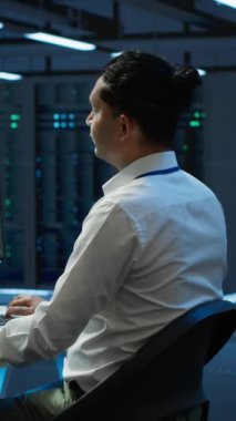 Dikey video geliştirici ve veri merkezini denetleyen iş arkadaşı, sistemin ağ oluşturma görevlerini yerine getirmesini sağlamak için geliştirmeler ve güncellemeler yapıyor. Sunucu odasındaki ekip çalışması izleme ağı
