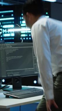 Veri merkezinde dikey video mühendisi bilgisayara yazılım yüklüyor, sorun çıkarma sorunları, el kamerası görüntüleri. Sunucu merkezinde bilgi işlem uzmanı performans kriterleri belirliyor, kamera A