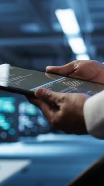 Çalışma alanındaki görevleri çözen ağ sistemlerinin kurulumundan sorumlu dikey video veri merkezi yöneticisiName BT çalışanı tarafından kullanılan ve sunucu çiftliği teçhizatında bakım yapan tableti kapat, kamera B