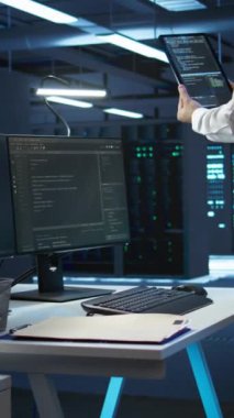 Dikey video veri merkezi bilgisayar bilimcisi ağ donanımı çözme görevlerinin kurulumundan sorumlu. İşteki Hintli adam sunucu odası altyapısında bakım yapıyor, kamera B
