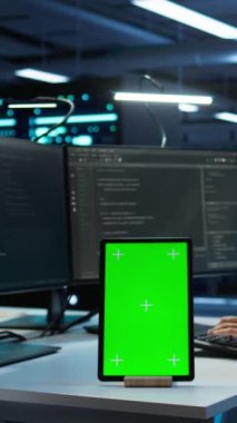 Veri merkezindeki dikey video yazılım geliştiricisi model tablet kullanarak güvenlik tehditlerini izliyor. BT uzmanı yeşil ekran aygıtı kullanıyor, sunucu odası yönetmeliklerine uyulmasını sağlıyor, kamera B