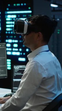 Yüksek teknoloji VR kulaklık takan ağ sistemlerinin kurulumundan sorumlu dikey video veri merkezi yöneticisi. BT çalışanı sanal gerçeklik teknolojisi kullanarak sunucu çiftliği teçhizatını tamir ediyor.