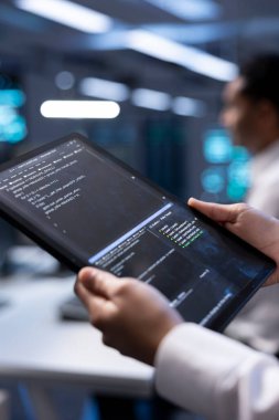 Sunucu merkezinde yönetici, rackmount performansını etkileyen güvenlik duvarı yanlış yapılandırmalarını bulmak için tablet kullanıyor. Denetleyici, veri aktarım hızının düşmesine yol açan sistem darboğazlarını kontrol ediyor, kapat