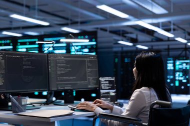 Belden aşağısı felçli biri. Sunucu çiftliğinde çalışıyor. Bakım işi yapıyor. Tekerlekli sandalyedeki mühendis ileri teknoloji veri merkezinde ileri viteslere ev sahipliği yapıyor.