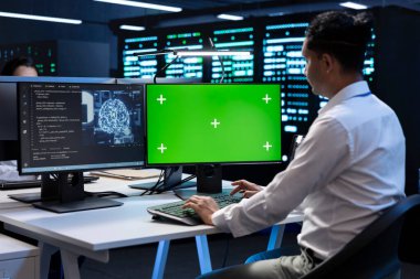Verileri işlemek için yapay zeka teknolojisiyle veri merkezindeki yeşil ekran bilgisayarda çalışan programcı. Derin öğrenme için kullanılan sunucu merkezi depolama verilerinde PC 'nin modellenmesi üzerine çalışan çözümleme görevleri