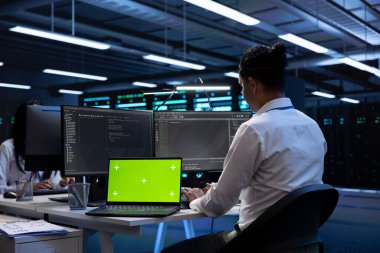 Sunucu merkezindeki mühendis veri depolama ekipmanlarını tamir etmek için izole ekran bilgisayarı kullanıyor. Hesaplama işlemleri yapan platformlarda hata ayıklama yapmak için kroma anahtar defteri kullanan profesyonel