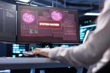 Sunucu merkezinde bilgisayar korsanlarının bilgi çalmasını engellemeye çalışan bir bilgisayar uzmanı. Yüksek teknoloji veri merkezindeki işçiler virüs kaynaklı güvenlik ihlali uyarısını düzeltmeye çalışıyorlar.