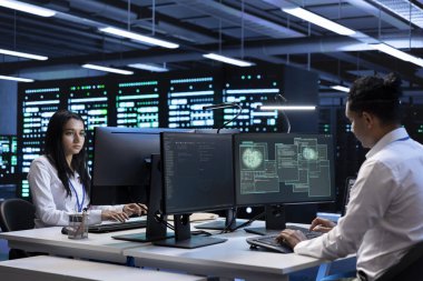 Programcılar donanımlarını kullanarak küresel bağlantıları desteklemek için sunucu odasındaki bilgisayarı kullanıyorlar. Bilgi işlem uzmanları dünya çapındaki ağı destekleyen veri merkezi altyapısını denetliyor