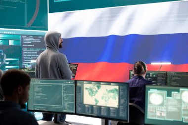 Büyük ekranda ABD bayrağı dalgalanırken devletin bilgisayarında çalışan bir bilgisayar korsanı. Siber güvenlik, siber tehdit analizi ve siber güvenliği sağlamak için küresel gözetim.