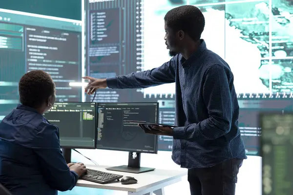 stock image Cyber defense team working in a governmental security operations center. Experts ensuring cybercrime prevention and data breach protection, examining information on a big screen.