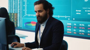 Ortak çalışma alanındaki proje detayları ve zaman çizelgelerini inceleyen bir şirket çalışanı, rekabetçi bir ortamda hedeflere ulaşmak için bütçe ve işlemler kuruyor. Kamera A.