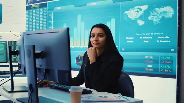 stock image Indian sales manager verifies infographics plan in company coworking space, works on creating business strategies and goals. Employee studying market dynamics and big data. Camera B.