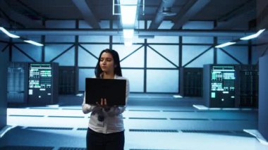 Veri merkezinde yürüyen programcı, dizüstü bilgisayarla donanımı tasarlıyor, uyguluyor ve yönetiyor, optimal performans ve güvenilirliği sağlıyor. Bilgisayarda sunucu merkezi kodlamada IT çalışanı, kamera B