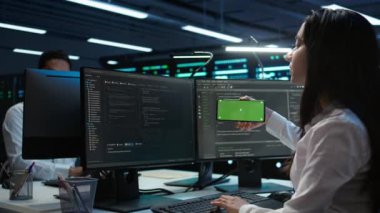 Veri merkezinde sunucuları yönetmek için cep telefonu kullanan bir teknisyen. Sunucu merkezinde, ağların güvenli ve düzgün çalıştığından emin olmak için izole ekran akıllı telefonu kullanan uzman, Kamera B
