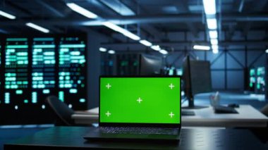 Yüksek teknoloji veri merkezindeki mühendislerin güvenlik tehditlerini izlemek için kullandıkları izole ekran laptopuna odaklan. İşçilerin yönetmeliklere uymalarını sağlamak için kullandığı krom anahtar defterini kapat