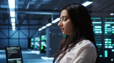 Veri merkezinde bilgisayar klavyesinde yazan programcı, sistemin ağ görevlerini yerine getirmesini sağlıyor. Bilgisayar, kamera B ile ağ trafiğini takip eden sunucu çiftliği bilişim uzmanı