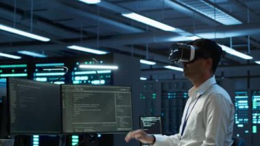 Veri merkezinde VR kulaklık takan mühendis bilgisayara yazılım yüklüyor, sorun yaratıyor. Sanal gerçeklik teknolojisi kullanarak sunucu merkezinde bilişim uzmanı, performans kriterleri oluşturuluyor, kamera A