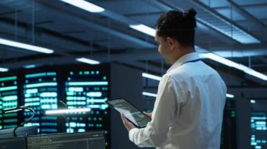 Sistem yöneticisi veri merkezini denetliyor, sistemin ağ oluşturma görevlerini yerine getirdiğinden emin olmak için geliştirmeler ve güncellemeler yapıyor. Sunucu odasında bilişim uzmanı Tablet, kamera A ile ağ trafiğini takip ediyor