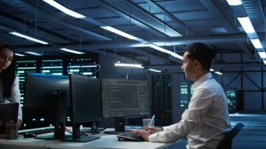Yüksek teknoloji veri merkezindeki programcılar tablet kullanarak sorun çözüyorlar. Sunucu çiftliğinde çalışan takım arkadaşları aygıt kullanarak, performans kriterleri oluşturarak, kamera B