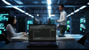 Veri merkezindeki laptop ekranında çalışan kodların kapatılması vites enerji tüketimini yönetmek için kullanılır. Sunucu çiftliğindeki bulanık arkaplanda yazılım geliştirici tarafından kullanılan dizüstü bilgisayara odaklan, kamera B
