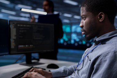 Bilgisayar bilimci sunucu odasını müşterilerin veri işleme gereksinimleri için optimize ediyor. Bilgisayar üzerinde yazıcı, veri merkezi ekipmanlarının verimli çalışmasını sağlar, kapatır