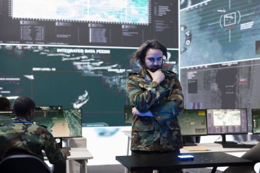 Askeri personel, bir hologramdaki küresel uydu görüntülerini inceliyor. Bölgedeki birlikleri izliyorlar. Eğitimli ordu subayı holografik projeksiyon yüksek teknoloji donanımı kullanıyor..