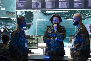 Bir hologram projeksiyonunun önemli gerçek zamanlı verilerini inceleyen çeşitli servis elemanları devam eden bir operasyonla ilgili fikirleri tartışıyorlar. Profesyonel askerler holografik görüntülerle çalışırlar..