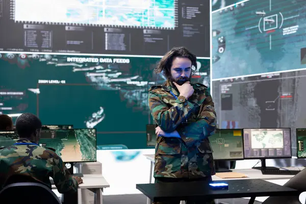 Askeri personel, bir hologramdaki küresel uydu görüntülerini inceliyor. Bölgedeki birlikleri izliyorlar. Eğitimli ordu subayı holografik projeksiyon yüksek teknoloji donanımı kullanıyor..
