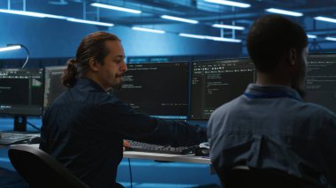 Sunucu odasını denetleyen ve bilgisayardaki kodları çalıştırırken kahve içen bir yönetici. Sunucu çiftliğindeki sistem yöneticisi programlaması bilgisayarda ve sıcak içeceğin tadını çıkarıyor