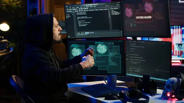stock image Cheerful hacker in apartment doing energic celebration after managing to steal sensitive data. Scammer happy after obtaining sensitive information from users using malware, camera A
