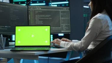 Veri merkezindeki programcı krom anahtar defteri kullanarak veri tabanlarını yönetir ve korur, veri bütünlüğü ve güvenliğini sağlar. İzole edilmiş ekran dizüstü bilgisayar ve kamera A kullanarak sunucu odası sistemlerini güncelleme uzmanı
