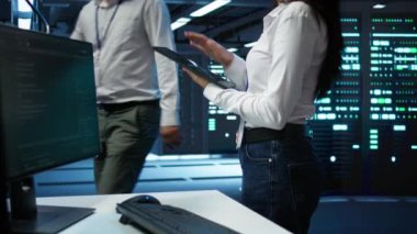 Veri Merkezi bilgisayar bilimcisi en iyi performans ve güvenilirliği sağlamak için altyapıyı tasarlıyor, uyguluyor ve yönetiyor. Sunucu odasındaki kadın tablet üzerinde kodlama yapıyor, kamera B