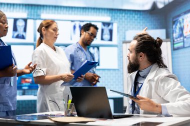 Tıbbi uzman, uygun tedavi planlarını sağlamak için insan anatomisi taramalarını inceliyor. Lisanslı sağlık uzmanlarından oluşan bir ekip, bir klinikte kapsamlı tıbbi hizmetler sağlamak için birlikte çalışmaktadır..