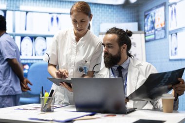 Uzmanlar röntgen sonuçlarını ve hasta bakımı stratejisini muayenehanede tartışırlar. Lisanslı doktorlardan oluşan bir ekip doğru teşhis ve etkili tedavi planları için birlikte çalışıyor..