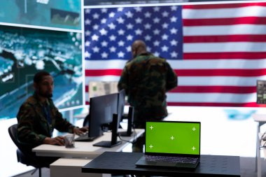 Amerikan ordusu yeşil ekranlı bir komuta merkezinde çalışıyor. Askerler ulusal güvenlik operasyonuyla ilgili uydu görüntülerini inceliyor. ABD askeri kontrol kulesi gözetim için.