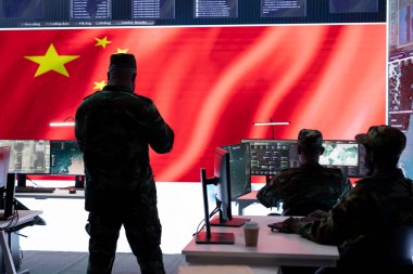 Military analyst reviews surveillance data on computer and big screen in Chinese military command post, spreading misinformation and inflicting fear among the population. Defense and security. clipart