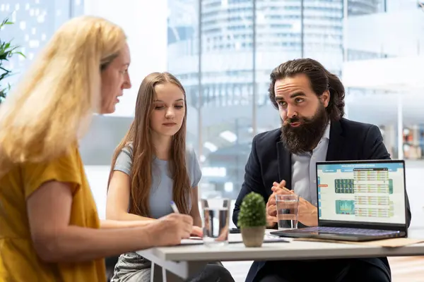 stock image Financial advisor showing laptop screen with stock market stats, assessing clients risk tolerance regarding portfolio investments. Broker does presentation on notebook about forex exchange