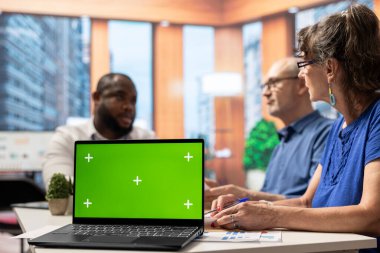 Finans bankacısı ve emeklilik planlarını araştıran yaşlı insanlar dizüstü bilgisayarda kroma anahtarıyla emekli çiftlere istikrar sağlıyorlar. Uzman, profesyonel tavsiyelerini sunuyor.