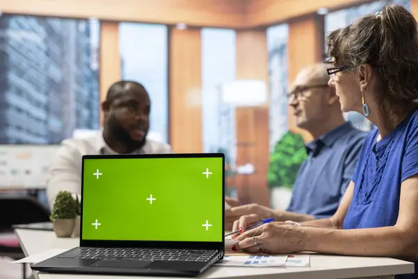 stock image Financial banker and elderly people looking for pension plans next to chroma key on laptop, ensuring stability for retired couple. Expert offering his professional advice.