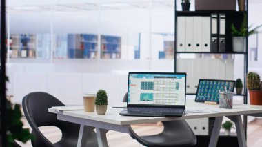 Yatırım tahvilleri ve diğer mali varlıkları içeren cihazların borsa portföyü olan boş bir ofis. Dizüstü bilgisayar ve tablette hisse senedi talep artışını gösteren gerçek zamanlı indeks göstergeleri