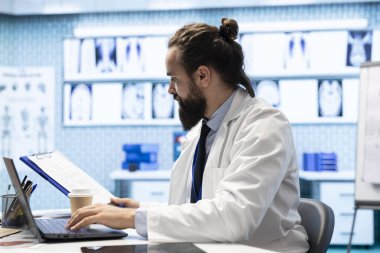 Özel bir klinikte tedavi için radyoloji test sonuçlarını inceleyen lisanslı bir doktor. Sigorta konusunda iyi tıbbi hizmetler sunan uzman bir doktor..