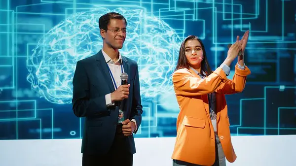 stock image Tech startup managers offer latest AI services during tech summit. Businesspeople using mic to do presentation for business investors interested in artificial intelligence, camera A