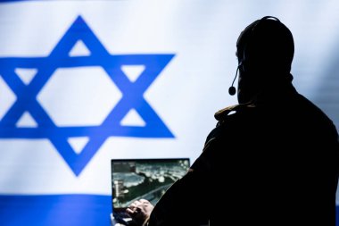 Telsiz ve uydu ekipmanları kullanarak Mossad için çalışan iletişim sistemleri operatörü, savaş desteği sağlıyor. İsrail ordusunun yayın ağlarını yöneten hareket memuru, İsrail bayrağı