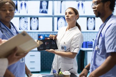 Radyografi tarama testine bakan çeşitli doktorlar organların durumunu, hastalıkla savaşmak için karaciğer ve akciğerleri kontrol ediyorlar. Sağlık hizmetleri hakkında konuşan bir grup doktor.