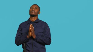 Güvenlik görevlisi işaret işareti yapıyor, istenmeyen erişimi durdurmakla görevli. Sert korumanın duraklama hareketi gösteren portresi, bölme hareketi, stüdyo arka planı, kamera A