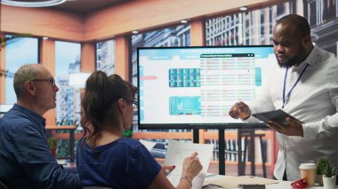 Finansal uzman, kurumda mevcut emeklilik planı seçeneklerini açıklarken, üst düzey çiftlere birikimlerini ve yatırımlarını güvence altına almalarında yardımcı oluyor. Komisyoncu emekli insanlara emekli maaşları hakkında danışmanlık yapıyor. Kamera B.