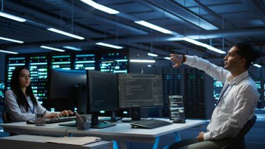 Veri merkezindeki yönetim, sistemin ağ görevlerini yerine getirmesini sağlamak için artırılmış gerçeklik teknolojisini kullanıyor. AR görselleştirme hologramına bakan sunucu odası çalışanı, ağ trafiğini takip eden, kamera B