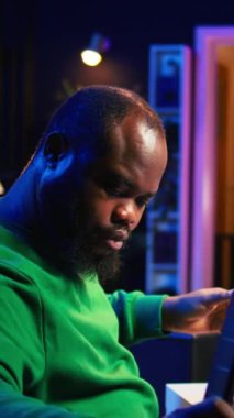 Dikey Video Yapımcısı, akustik enstrüman üzerine akorlar söylemek için mikrofon kullanarak yeni bir müzik bestelemektedir. Müzisyen söz yazarı karıştırma konsolu ve yazılımı ile çalışır, gitarist